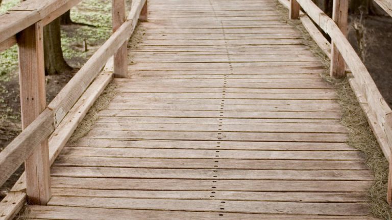 Wooden walkway of a stress-laminated timber bridge, showcasing sustainable design and natural materials in urban infrastructure.